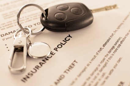 insurance policy papers with car key on top